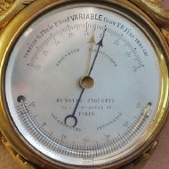 Miniature wall barometer with thermometer.